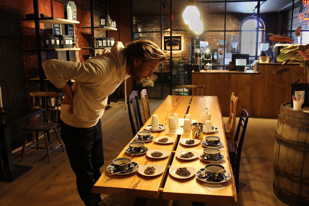 Kaffeprovning förbereds: koppar på ett långt träbord i Stockfors Coffee Roasters kafé